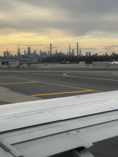 Airplane taking off from Buffalo airport with a backdrop of the city skyline.