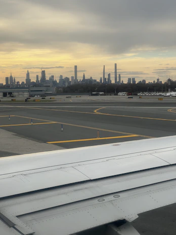 Airplane taking off from Buffalo airport with a backdrop of the city skyline.