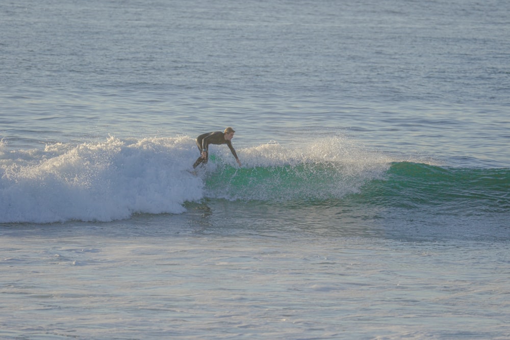 a man riding a wave on top of a surfboard