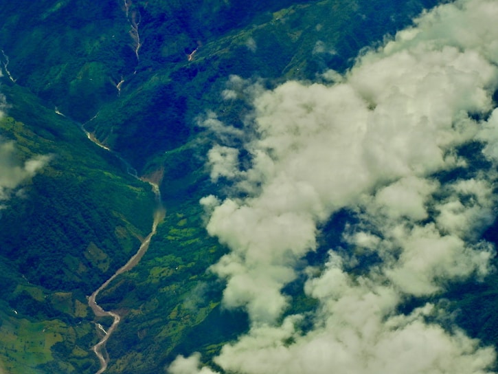Aerial view of Ecuador's lush green mountains captured by a drone at sunset.