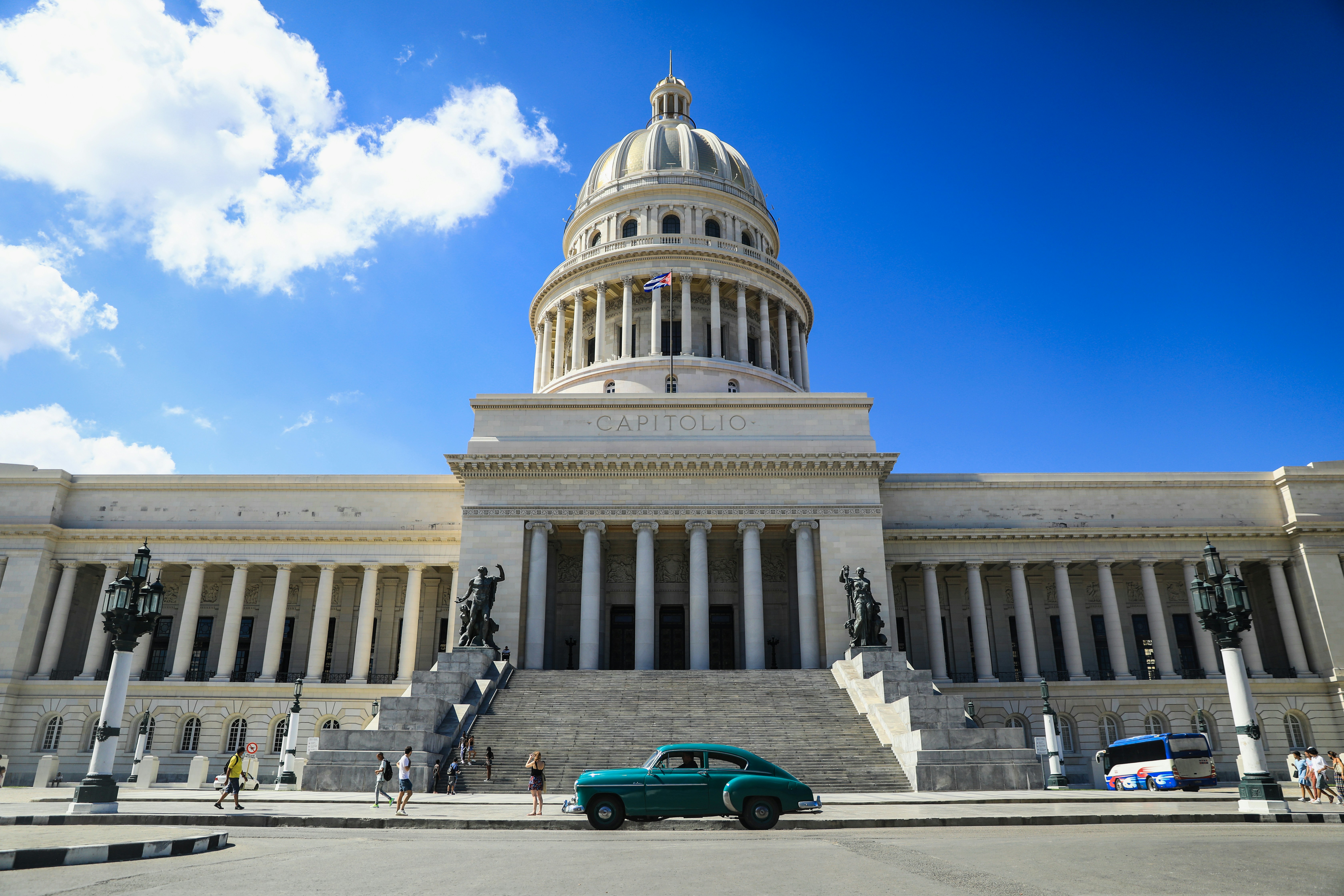 a green car parked in front of a large building, 