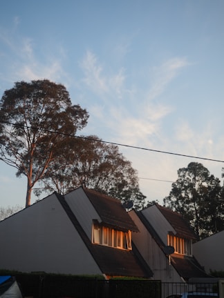 Before and after photo of a roof replacement on a suburban home under bright daylight.