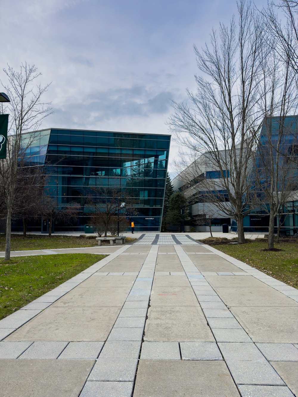 a walkway in front of a glass building