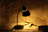 A warm glowing pagoluz lamp illuminating a small wooden desk with books.