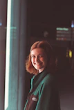 A woman standing in front of a window smiling