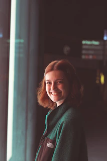 A woman standing in front of a window smiling