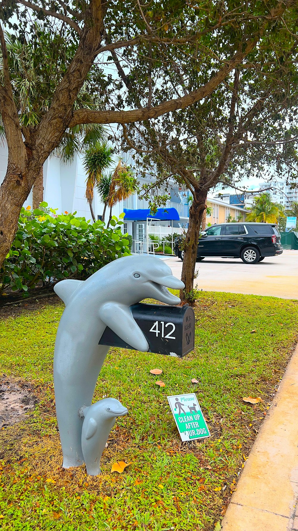 une statue d’un dauphin tenant une boîte aux lettres