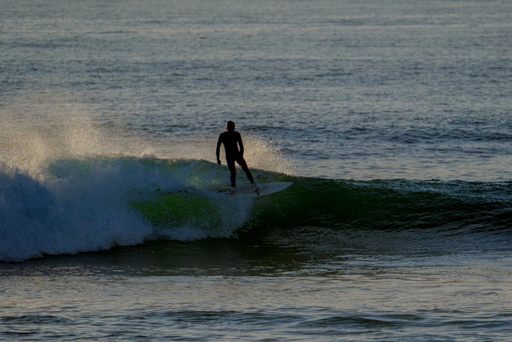 a man riding a wave on top of a surfboard