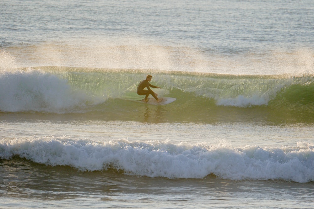 a man riding a wave on top of a surfboard