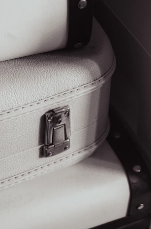 Close-up of a sleek black Travora suitcase with gold accents on a marble floor.