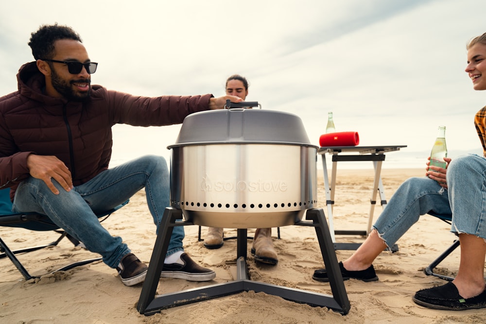 a man and a woman sitting in chairs on the beach