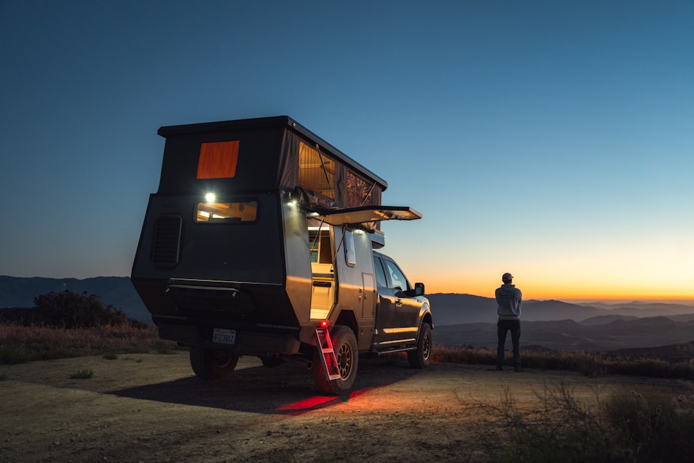 un uomo in piedi accanto a un camion con un camper sopra