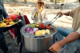 a man and a woman cooking food on a grill