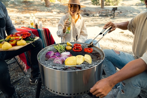 a man and a woman cooking food on a grill