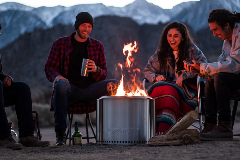 a group of people sitting around a fire pit