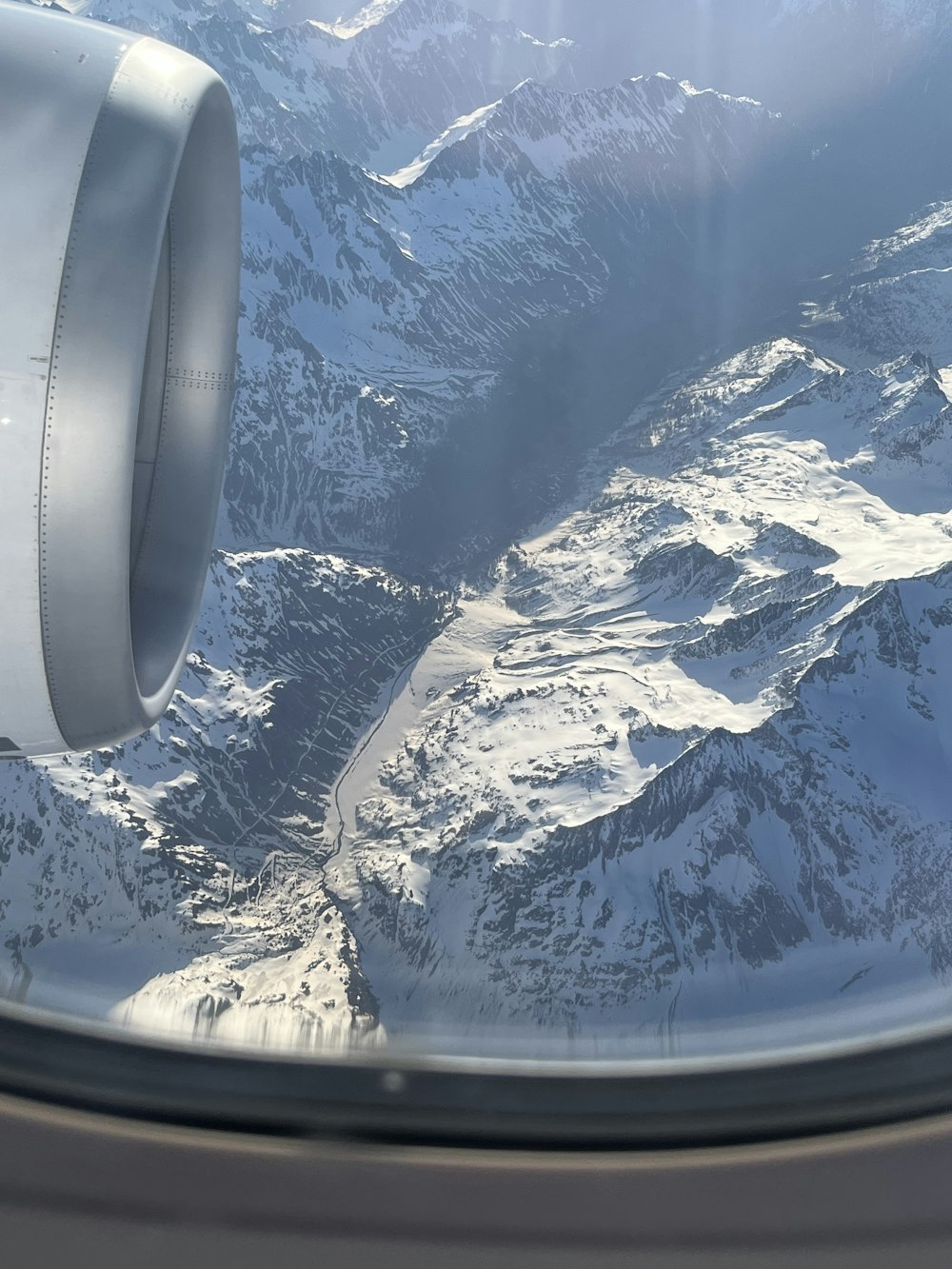 a view of a snowy mountain range from an airplane window