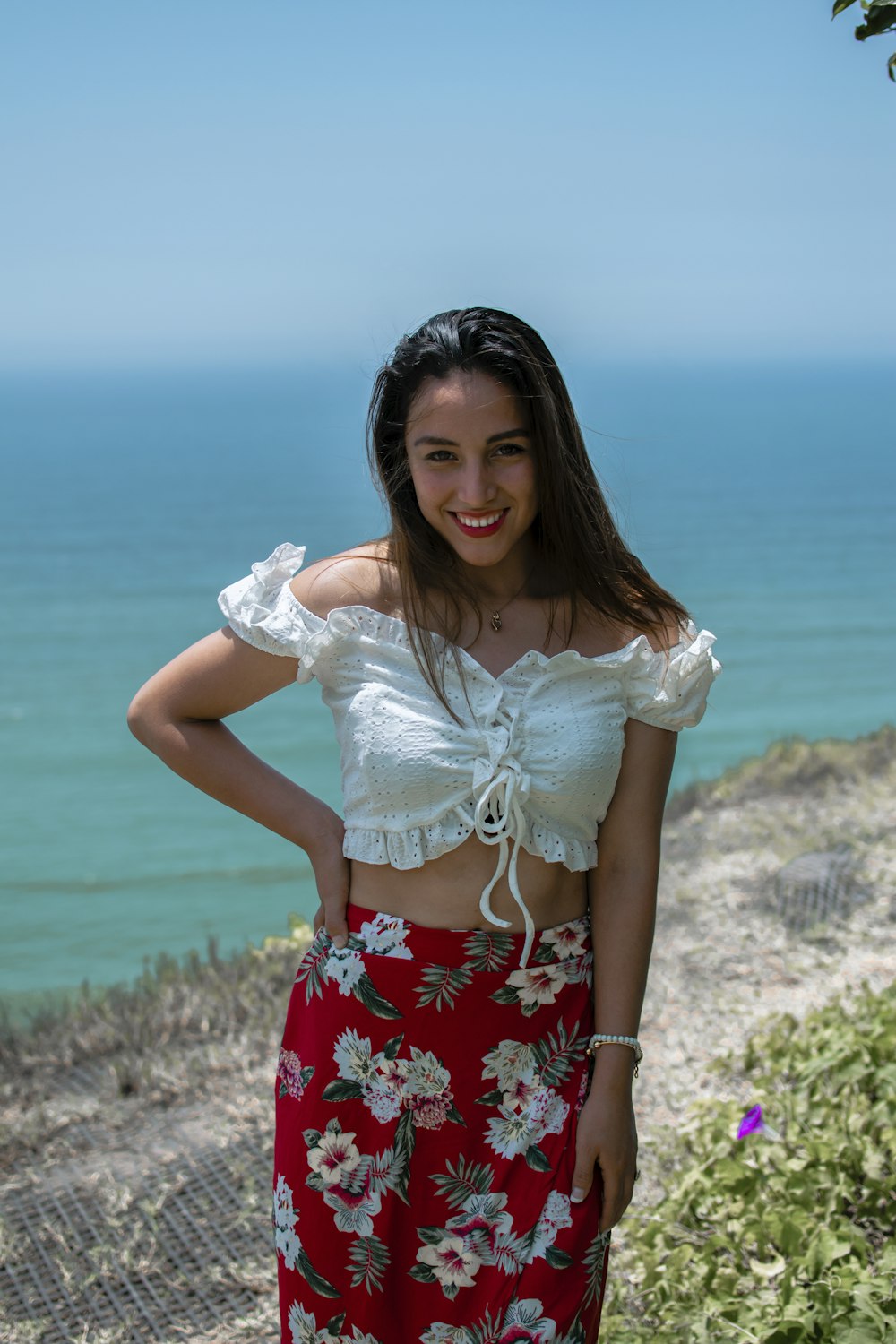 a woman standing on a cliff near the ocean