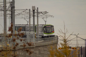 A modern tram-train gliding smoothly along the Kinshasa to Maluku route under a bright sky.