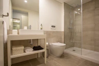 a white toilet sitting next to a walk in shower