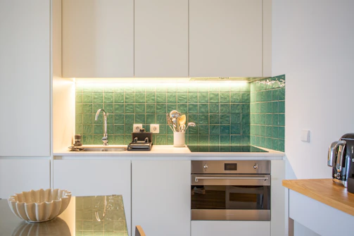 a kitchen with a sink, stove, microwave and toaster oven