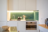 a kitchen with a sink, stove, microwave and toaster oven