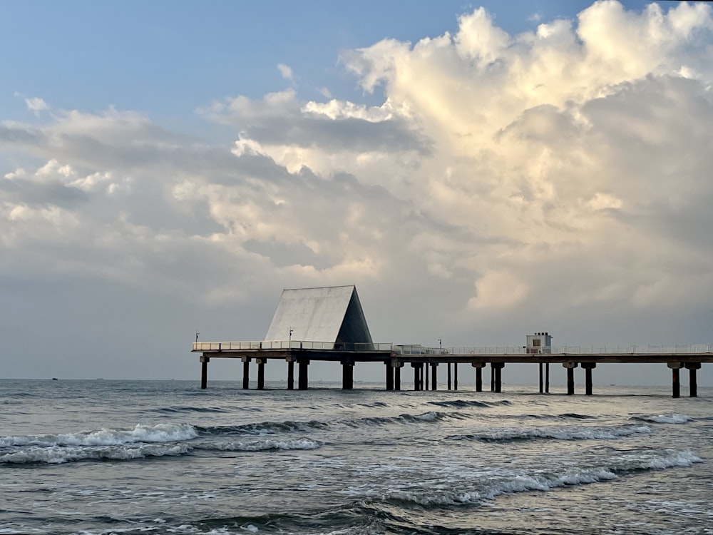 a pier on the ocean with a cloudy sky