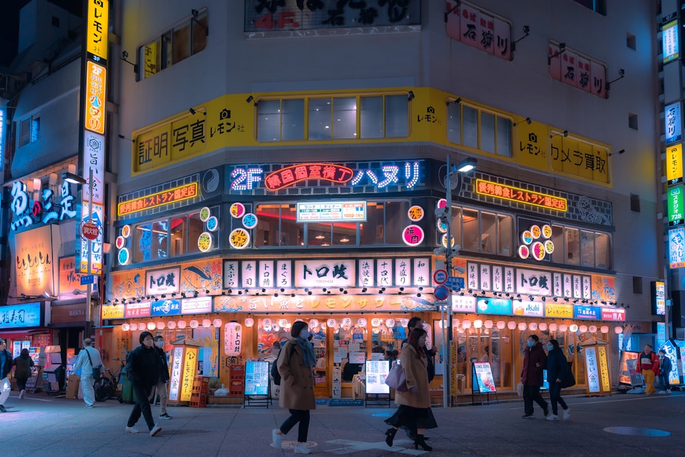 a group of people walking down a street at night