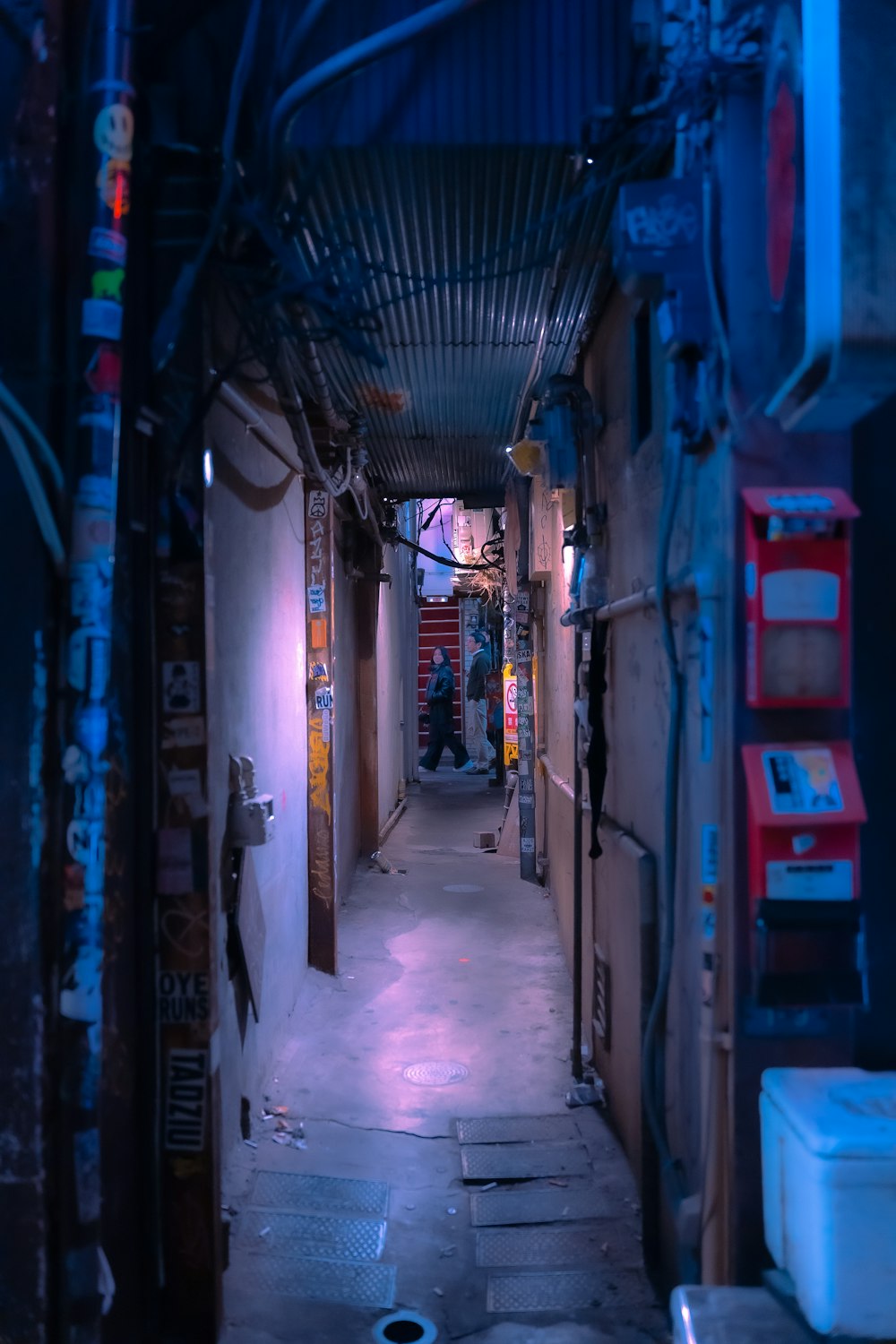 a narrow alley way with a toilet in the middle