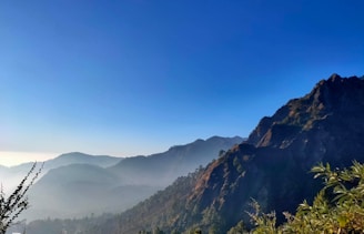 a view of a mountain range with trees in the foreground