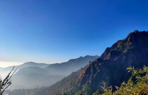 a view of a mountain range with trees in the foreground