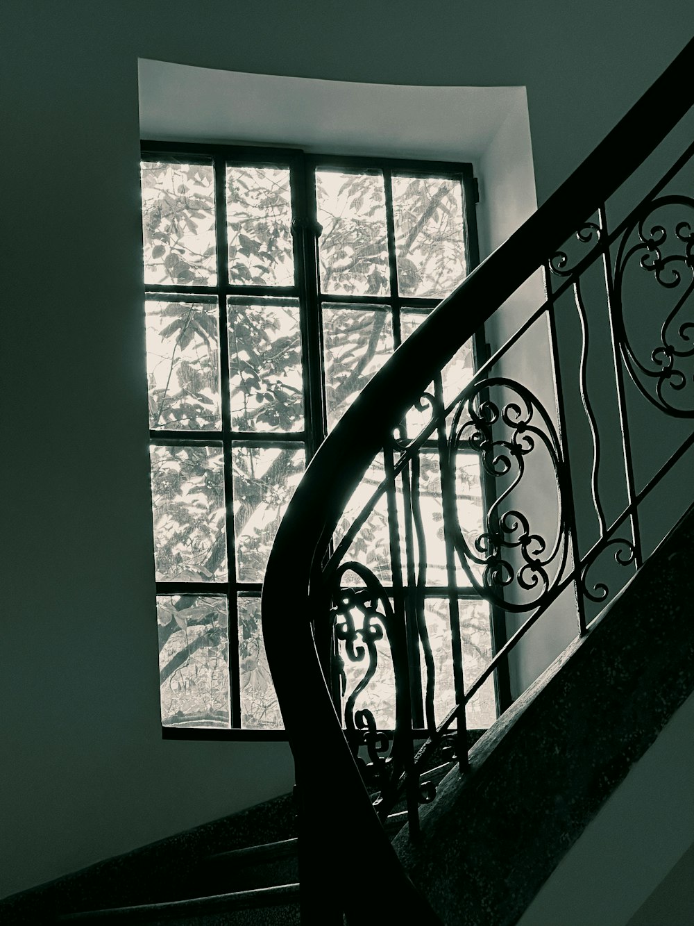 a black and white photo of a staircase and a window