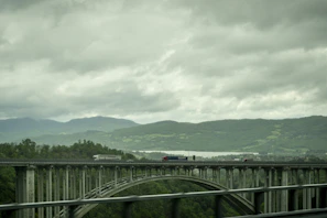 A Yatravistara truck crossing a historic bridge under a clear blue sky.