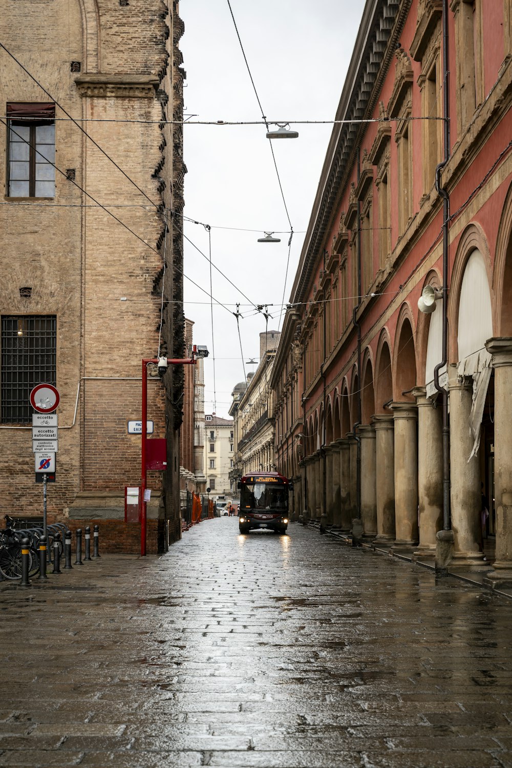 a wet street with a car parked on the side of it
