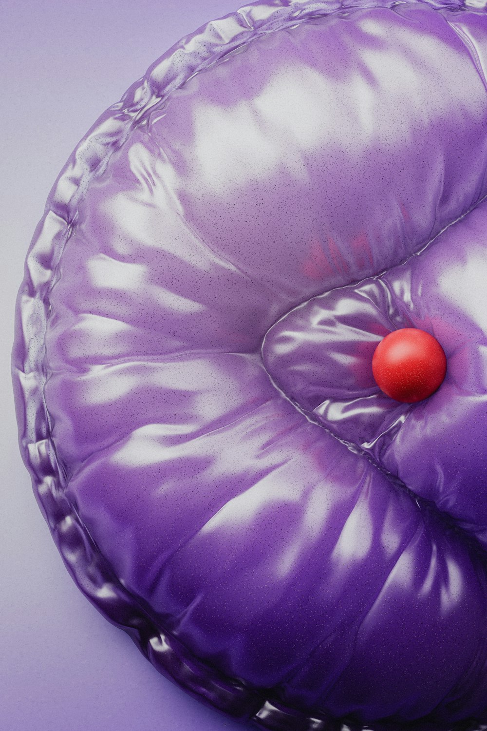 a purple pillow with a red button on it