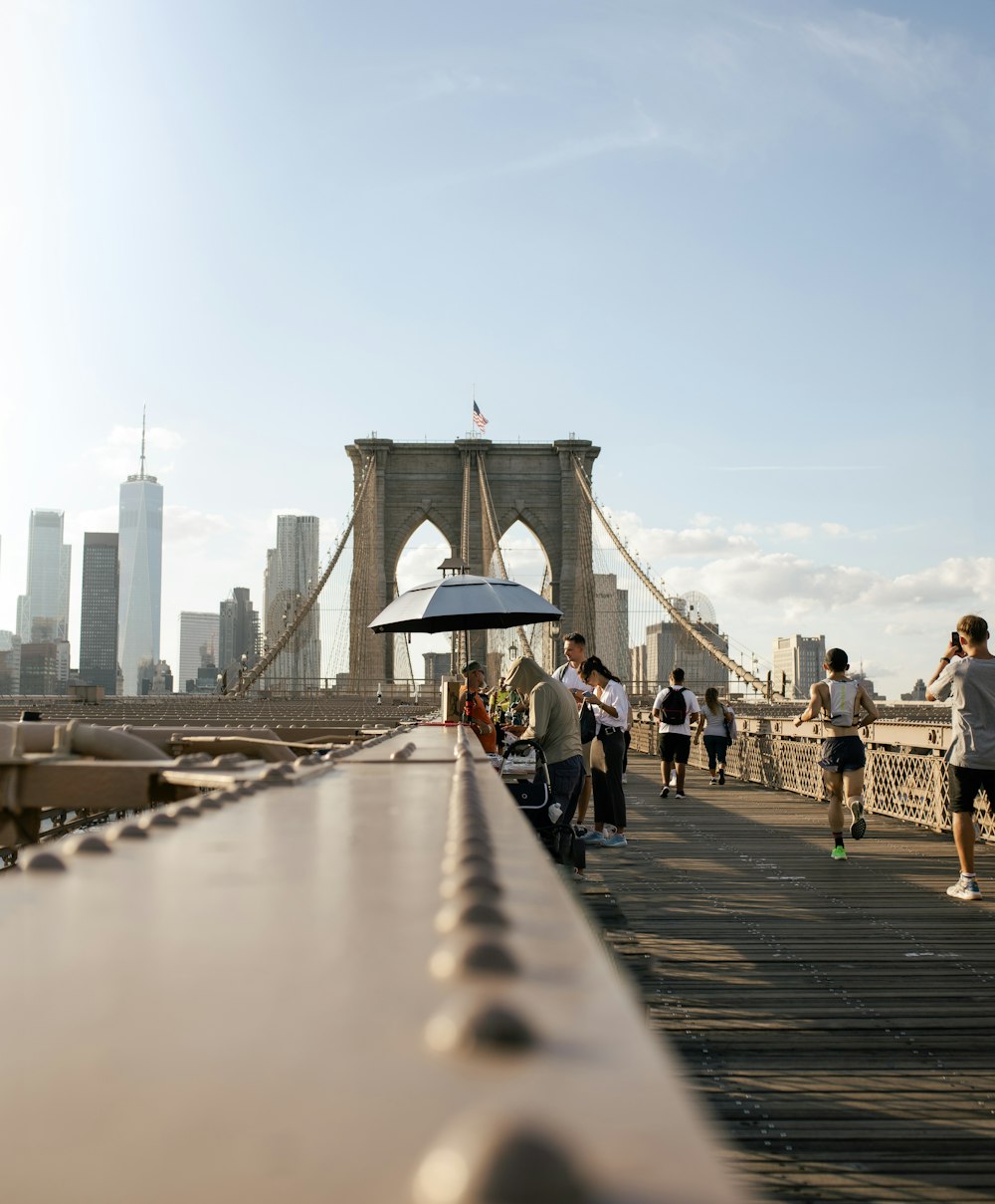 a group of people walking across a bridge