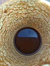 A close-up of a traditional Turkish coffee cup with coffee grounds forming shapes inside.