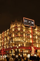 A festive commercial building adorned with synchronized Christmas lights glowing warmly at night.