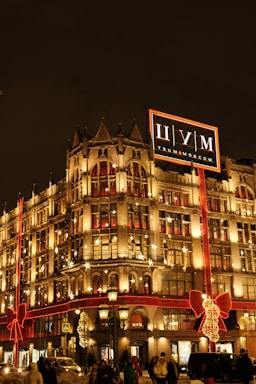 A festive commercial building adorned with synchronized Christmas lights glowing warmly at night.