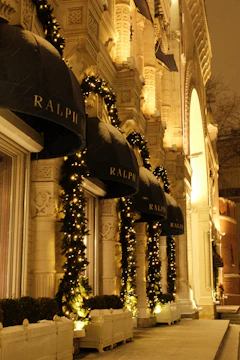 A commercial storefront decorated with vibrant, permanent holiday lights highlighting its architectural features.