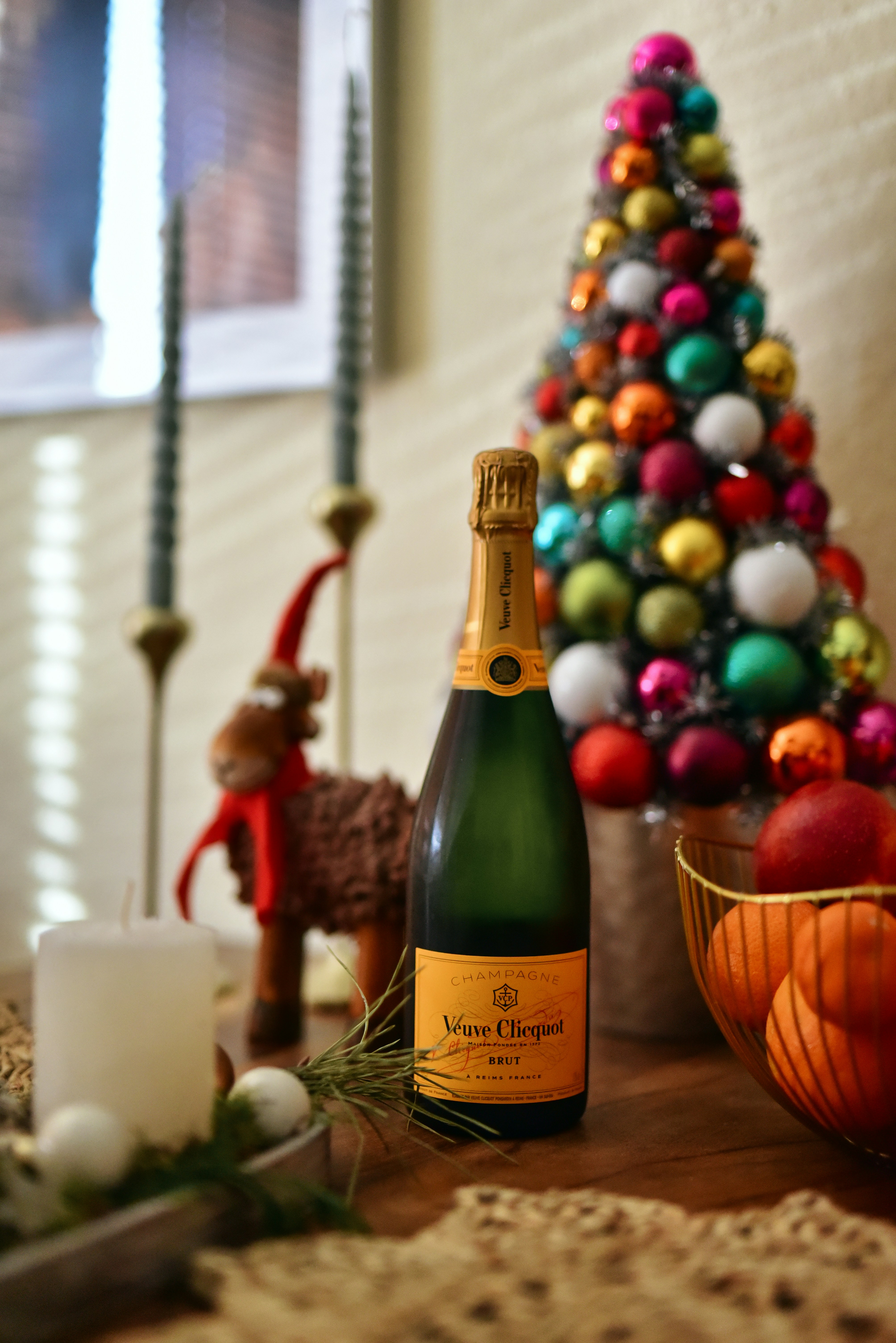 Eine Flasche Champagner neben einem Weihnachtsbaum