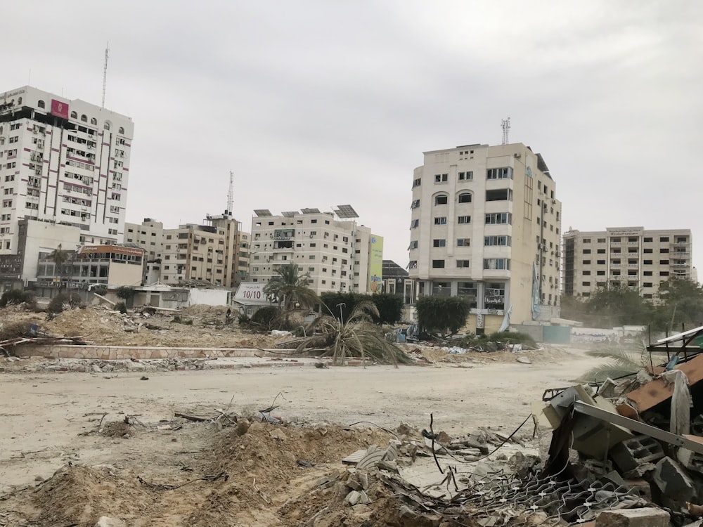 a pile of rubble in a city with buildings in the background