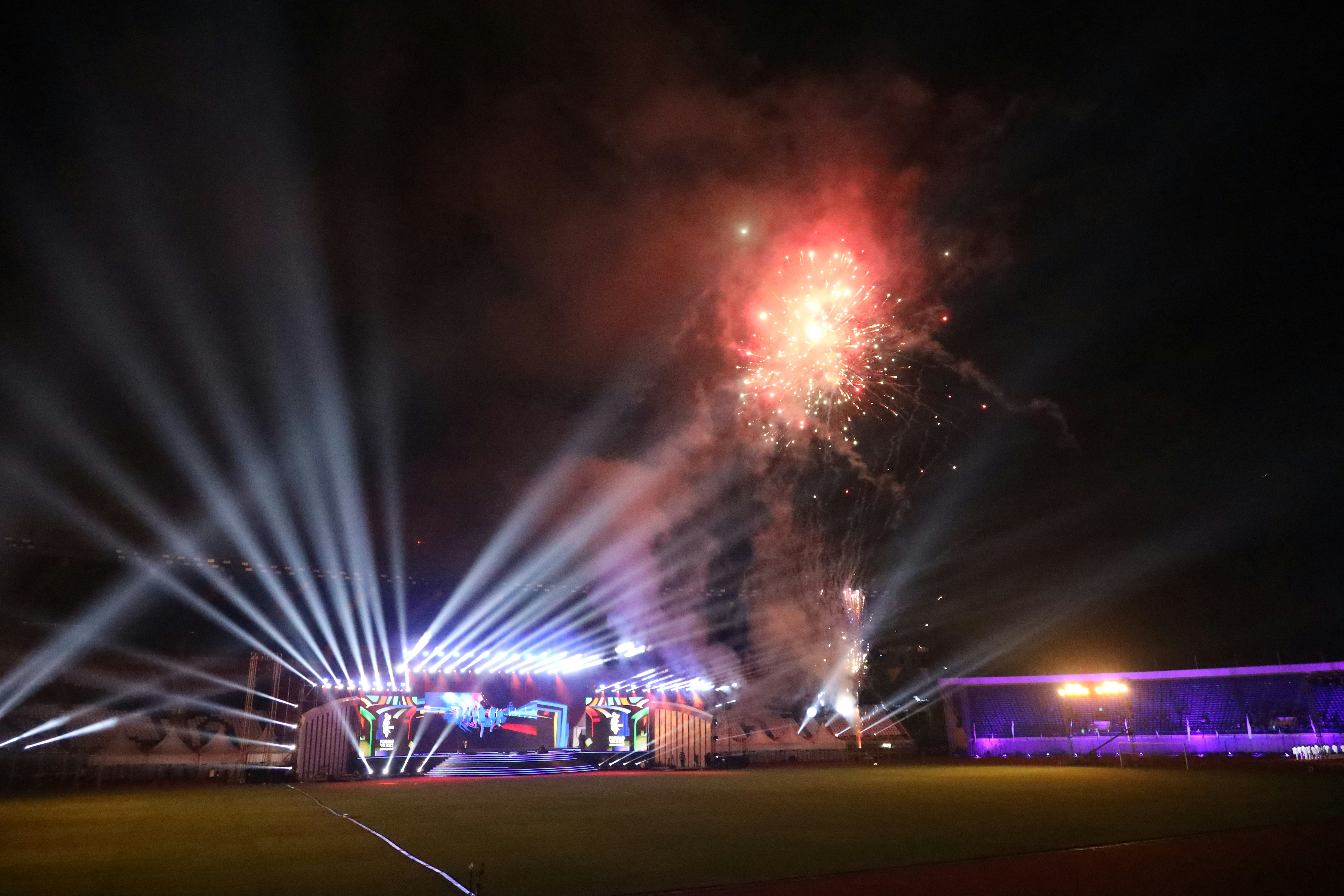 Dark dramatic explosion and light beams in a night sky during a live event
