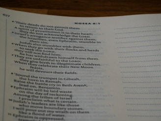 A close-up view of a page from a printed book, featuring text from the Bible. The chapter heading 'Hosea 6:1' is visible, with verses discussing themes such as Israel's deeds, arrogance, and spiritual struggles. The text appears on an off-white page with a visible page number, '677', in the top corner.