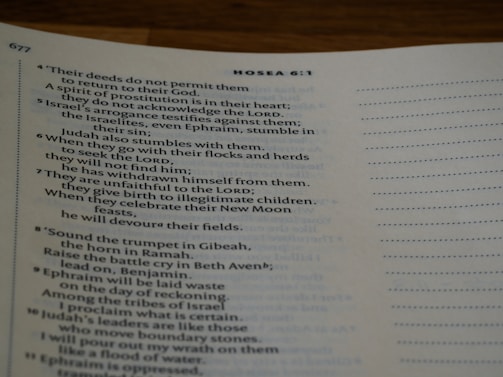 A close-up view of a page from a printed book, featuring text from the Bible. The chapter heading 'Hosea 6:1' is visible, with verses discussing themes such as Israel's deeds, arrogance, and spiritual struggles. The text appears on an off-white page with a visible page number, '677', in the top corner.
