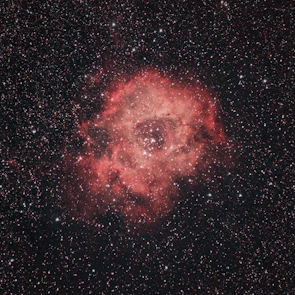 A vibrant nebula glowing with reds and blues against the blackness of space.