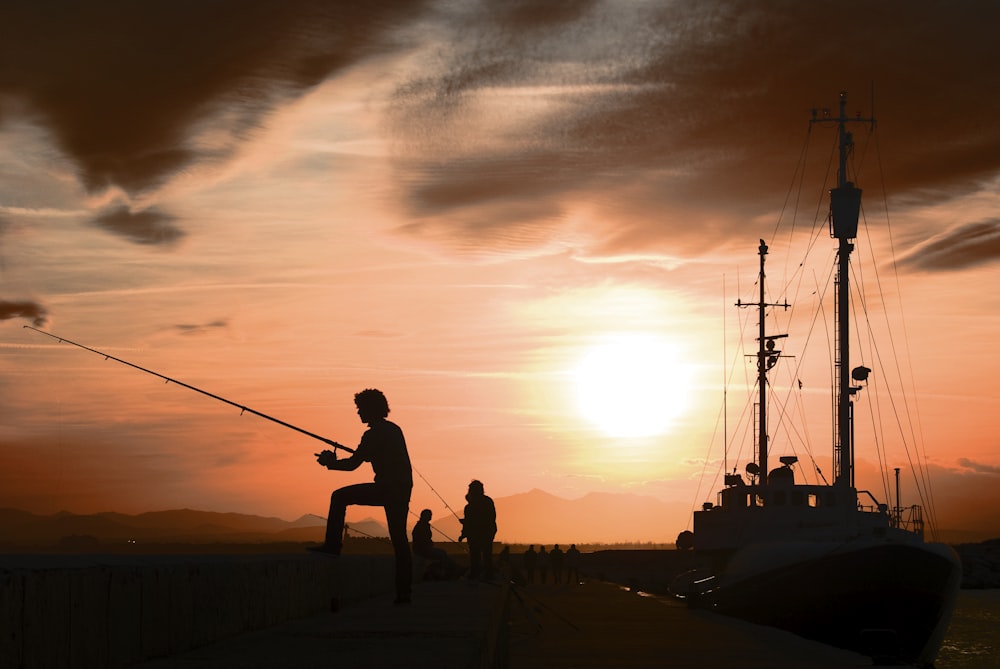 a man standing on a dock while holding a fishing pole