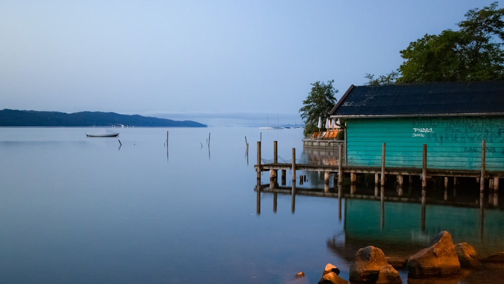 a boat is sitting on the water near a dock