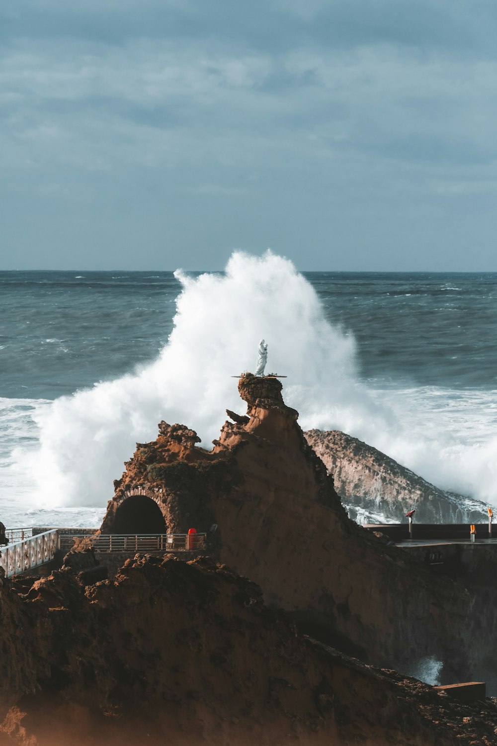 a person standing on top of a cliff near the ocean