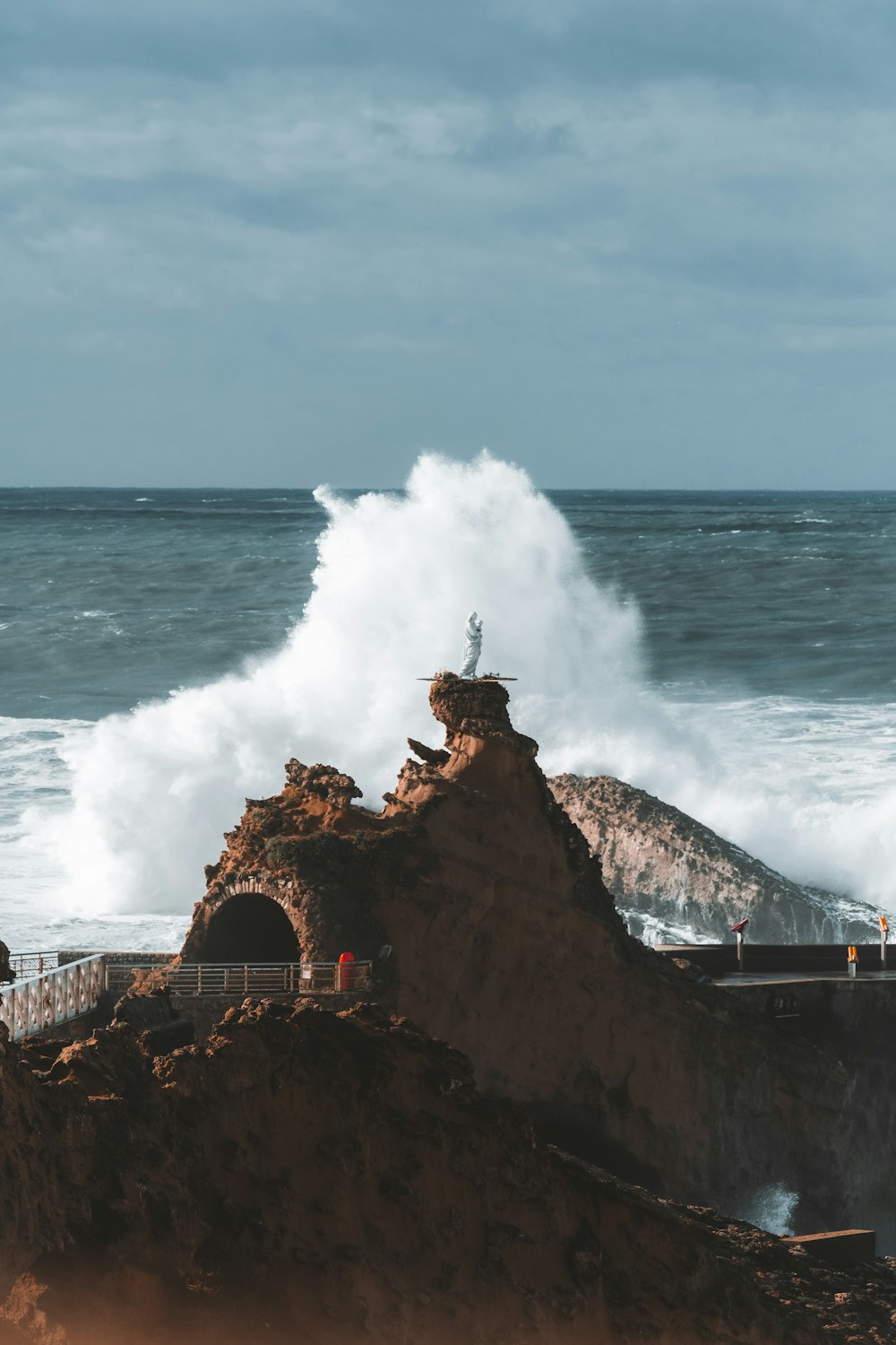 une personne debout au sommet d’une falaise près de l’océan