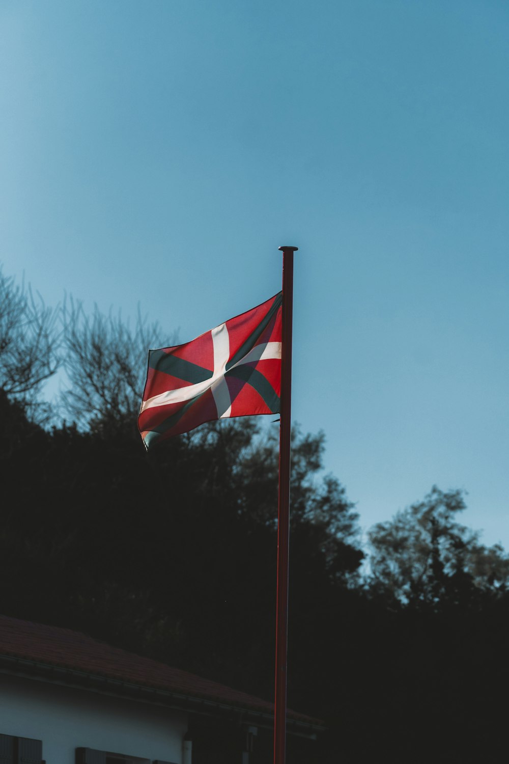 a red and white flag flying in the wind